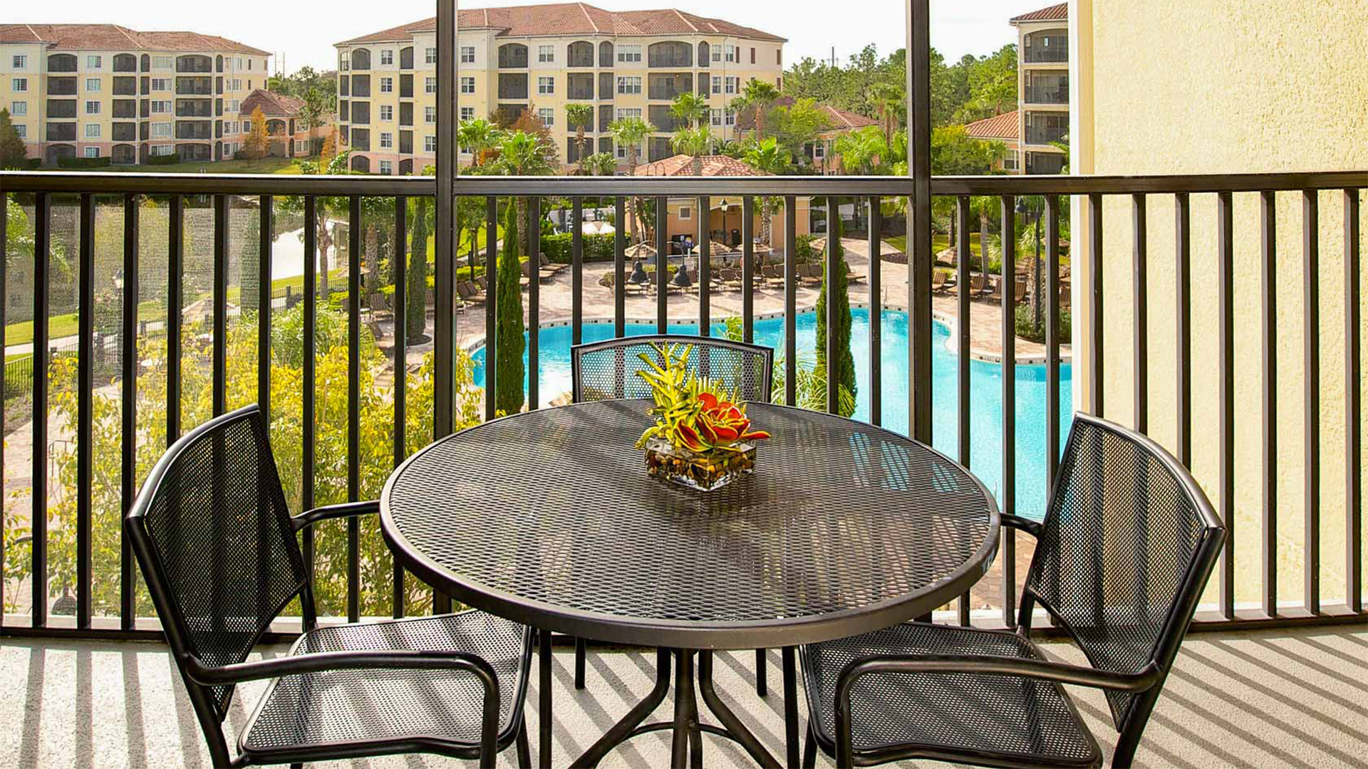 a table with chairs around it on a deck by a pool
